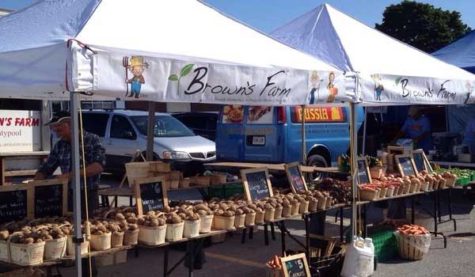 A booth at a farmers' market. The booth has a logo which reads "Brown's Farm"