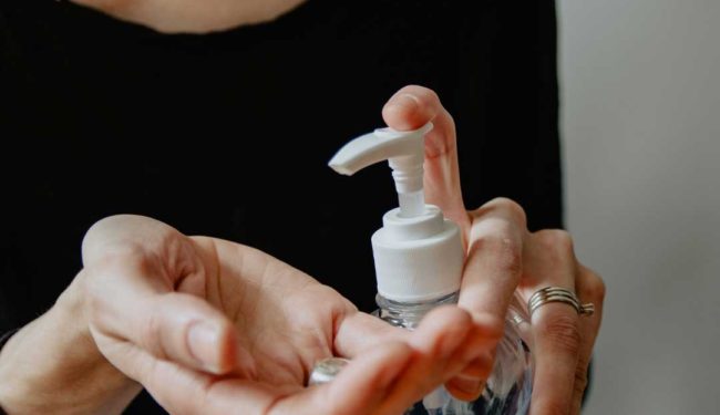 Close-up of a person applying hand sanitizer.