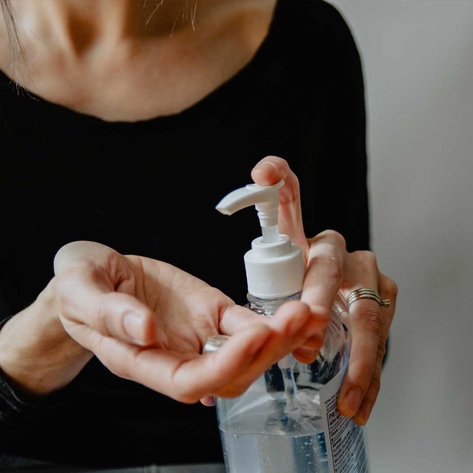 Close-up of a person applying hand sanitizer.