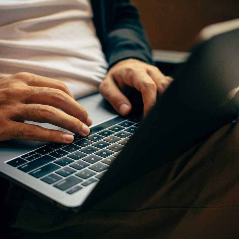 A person types on a laptop keyboard