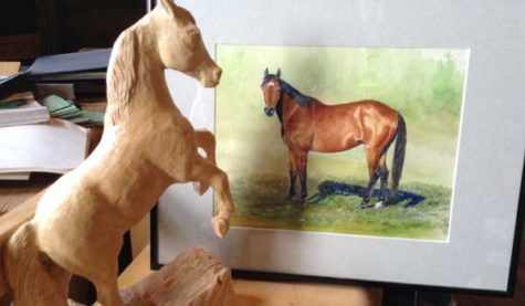 A carving of a horse shown next to a painting of a horse